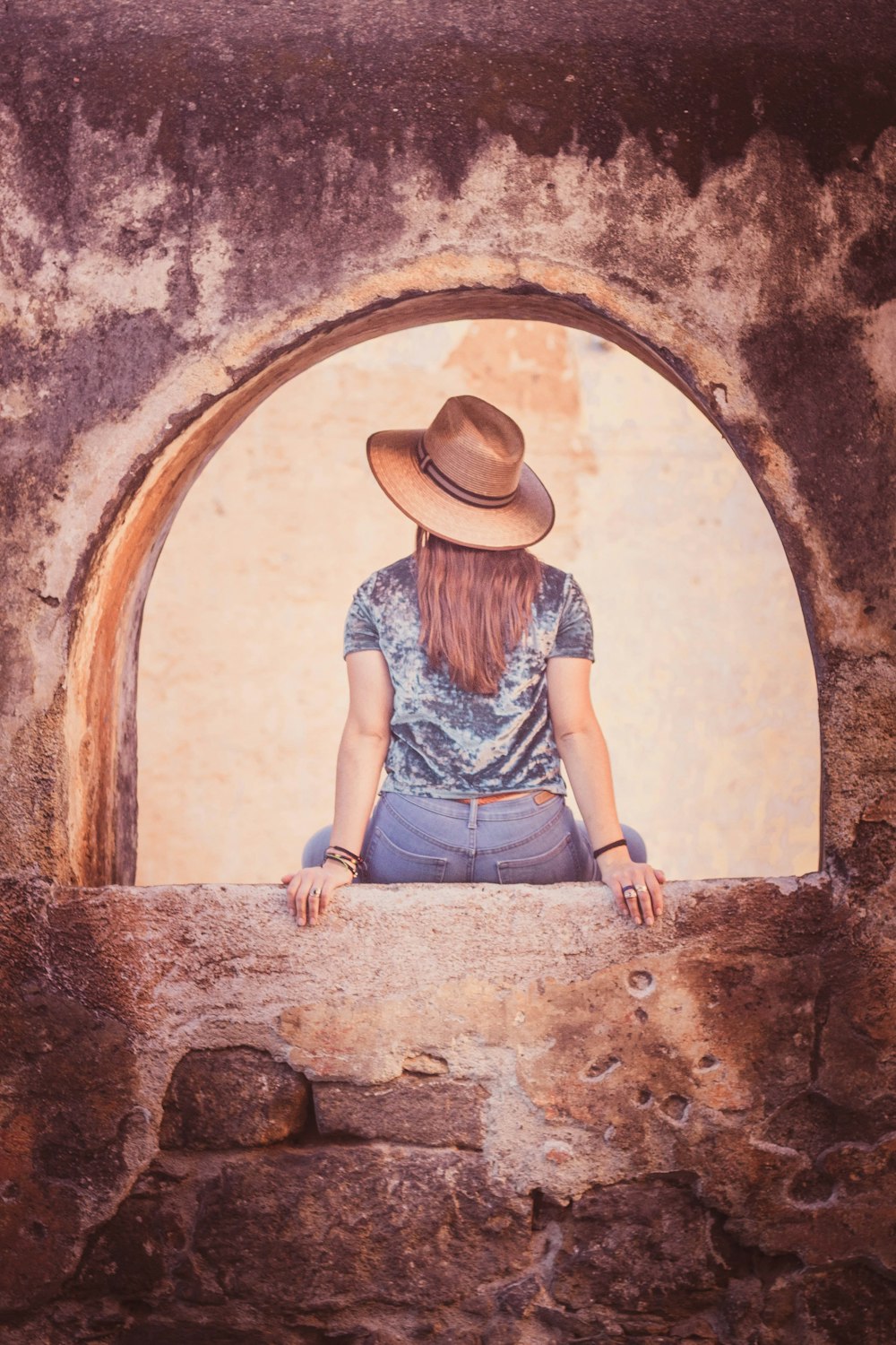 woman sitting on concrete frame painting