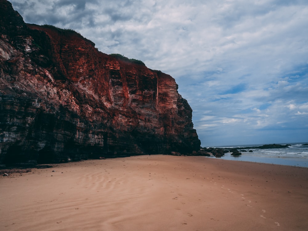 brown rock formation beside sea