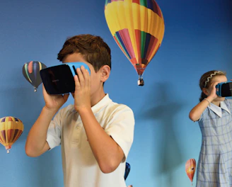 boy and girl uses VR goggles in front hot air balloons wallpaper