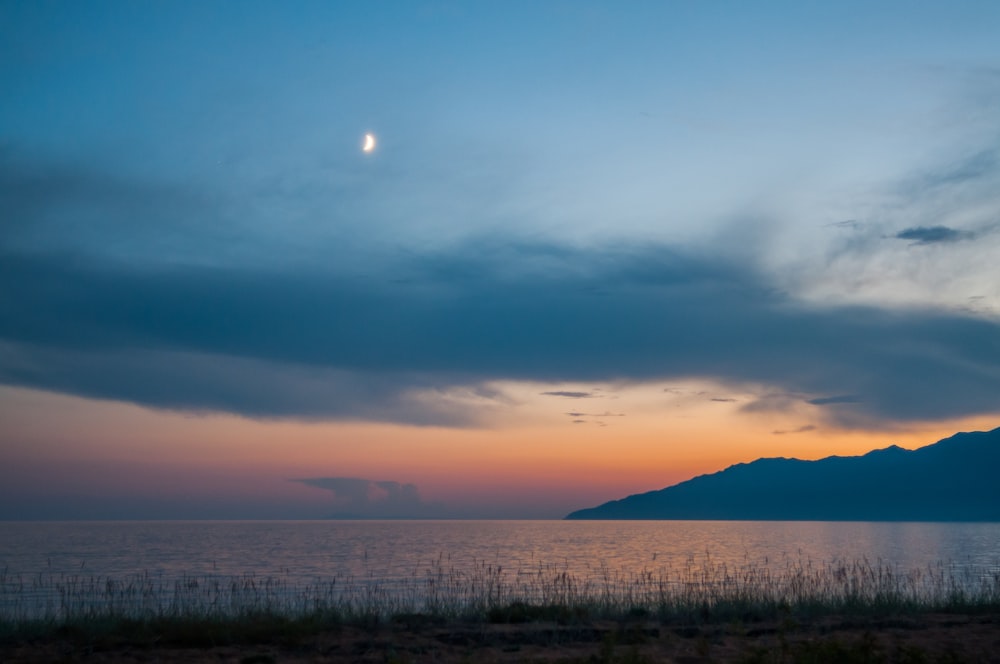 calm sea under orange and blue skies