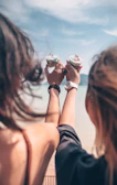 Family laughing together while sharing colorful ice cream cups on a sunny terrace.