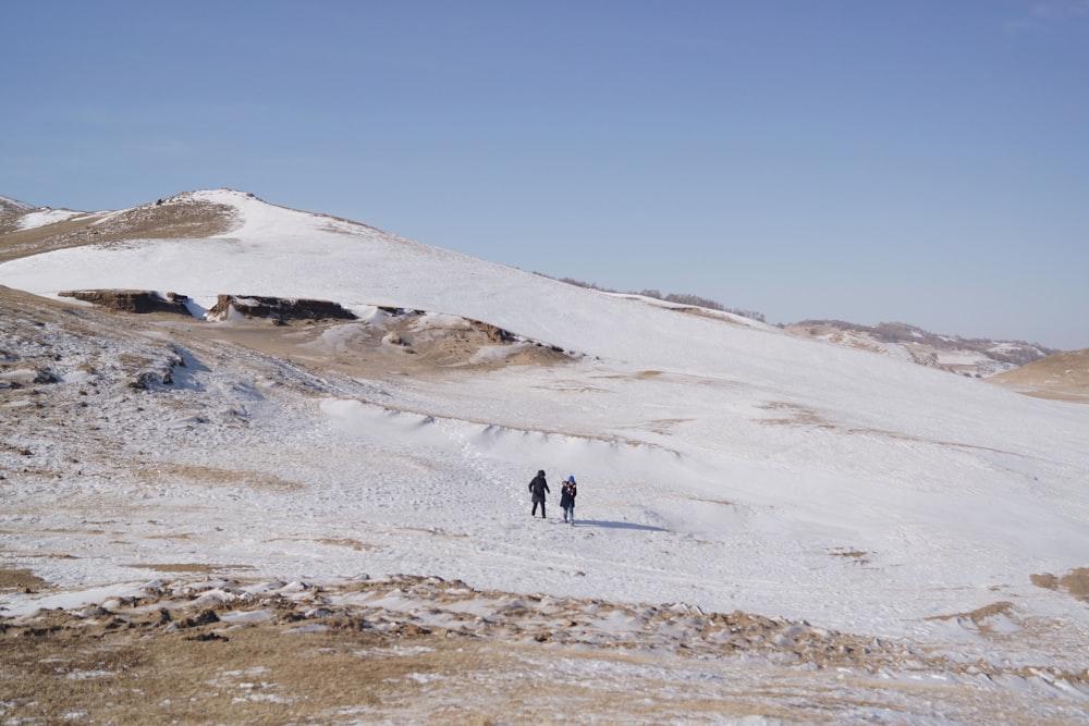 two persons walking on mountain