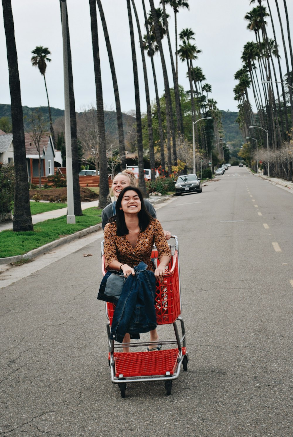 woman riding red shopping cart