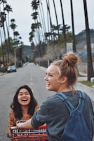 A group of young women laughing and enjoying a sunny outdoor shopping trip.