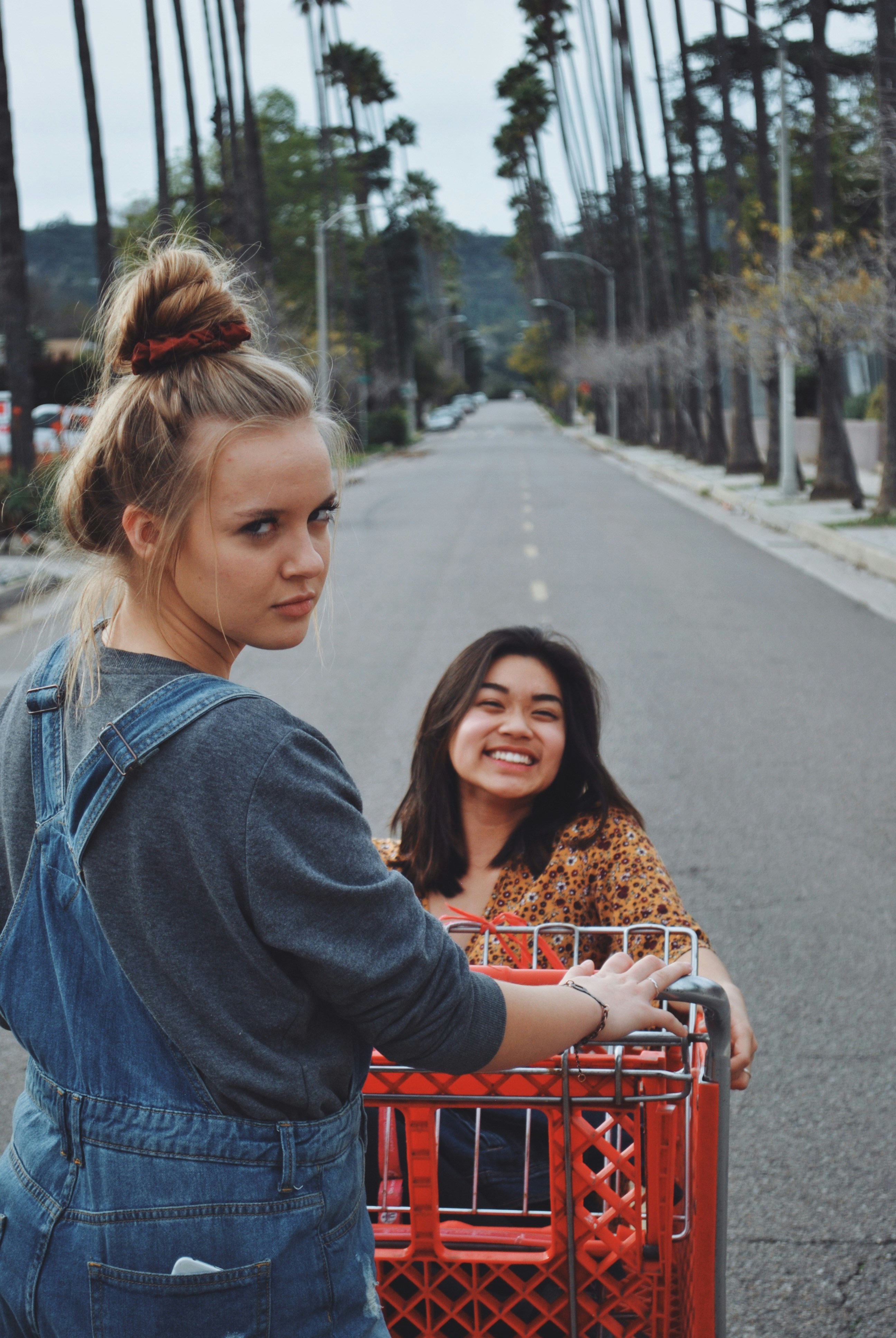 shallow focus photo of woman sitting in red shopping cart