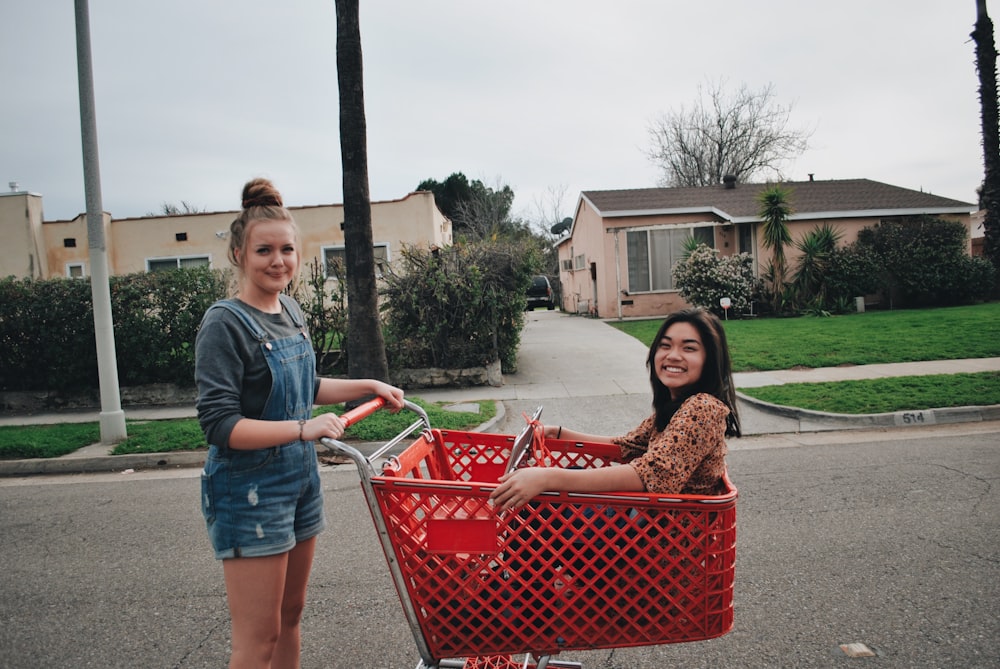 woman sitting on red shopping cart