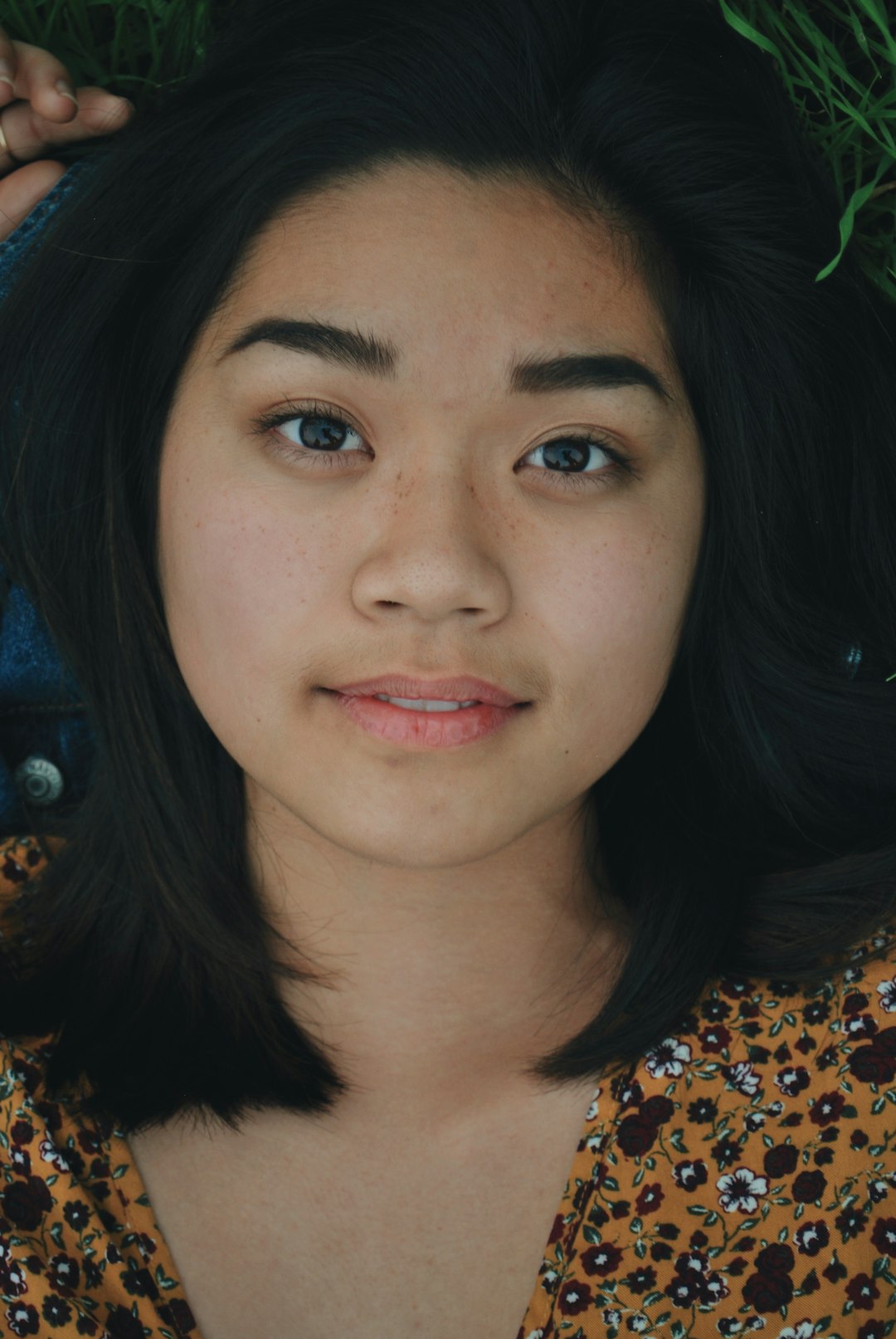 shallow focus photo of woman in brown and white floral top