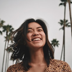 woman in brown floral dress standing and smiling