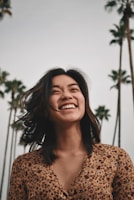 woman in brown floral dress standing and smiling