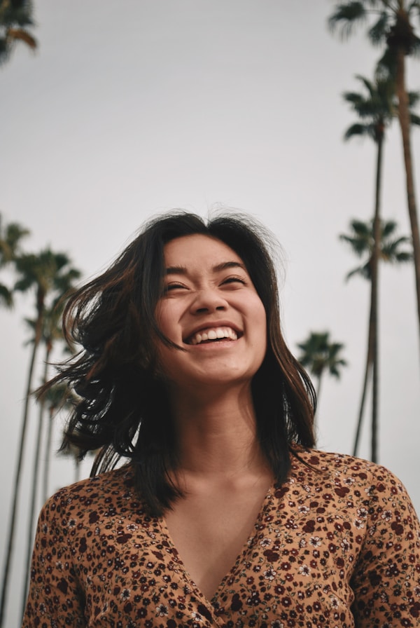 woman in brown floral dress standing and smilingby Joel Mott