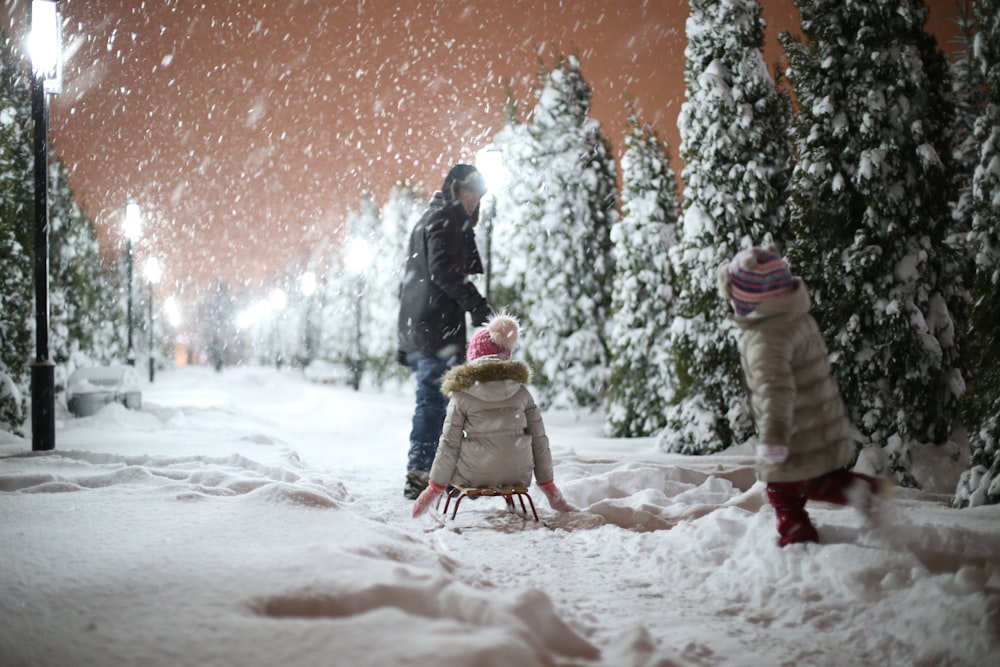 family of three playing during winter