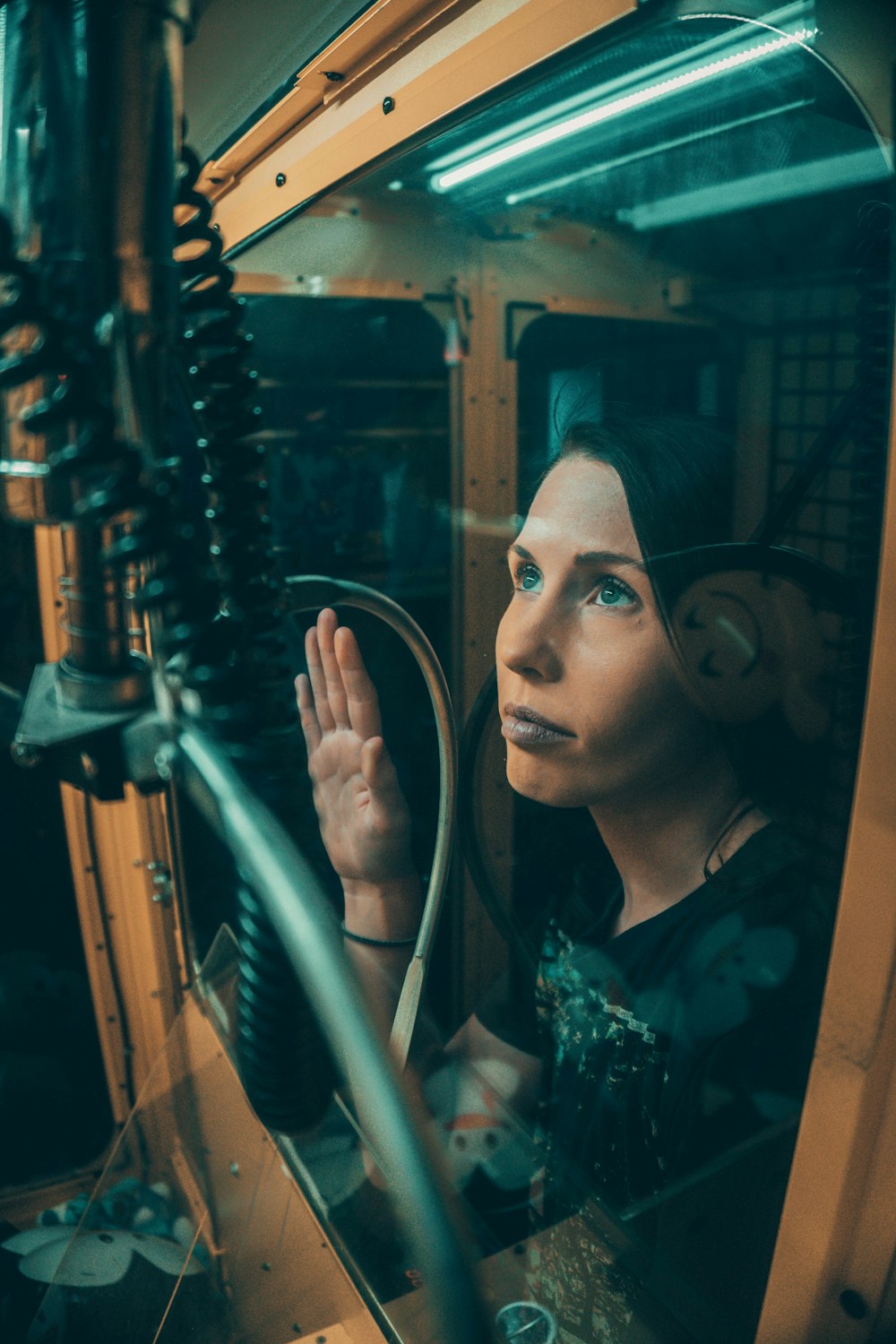 woman in black t-shirt looking through the glass window