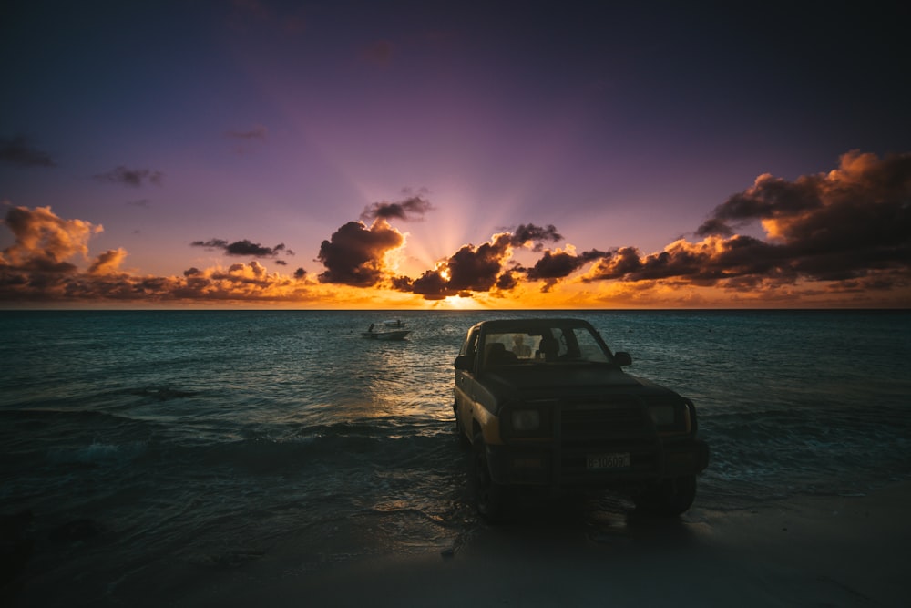 vehicle on seashore during sunset