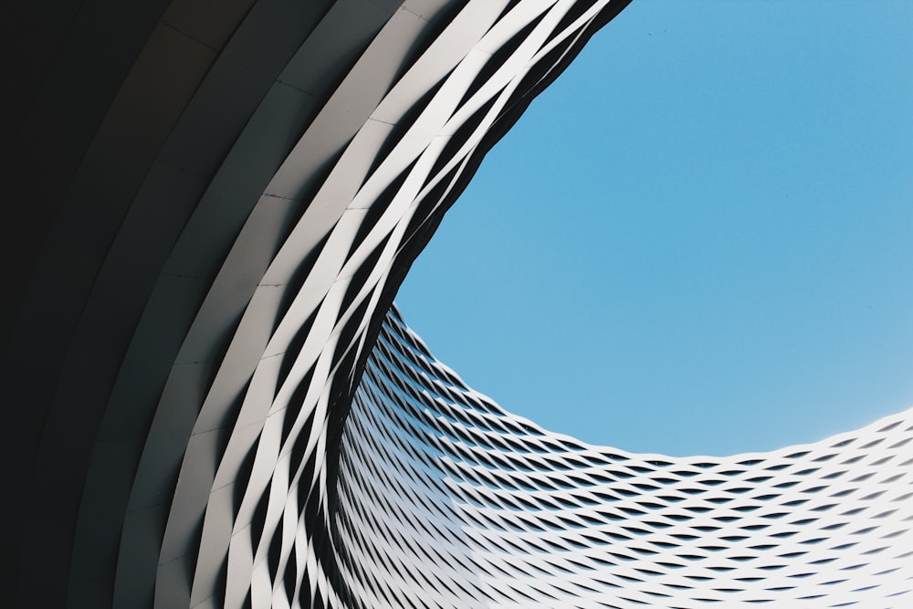 grey curved concrete structure under blue sky during daytime