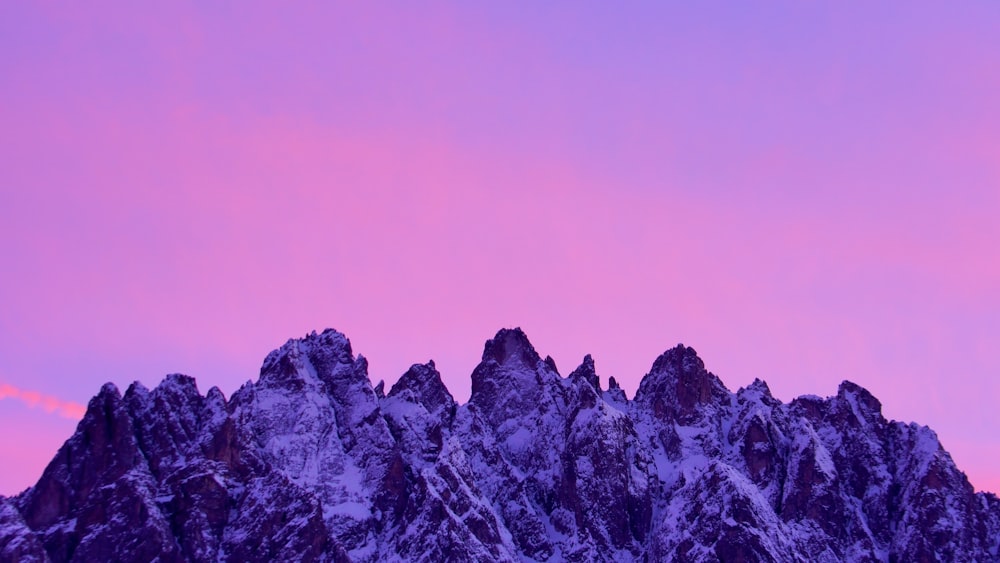 pink sky over snow rocky mountains