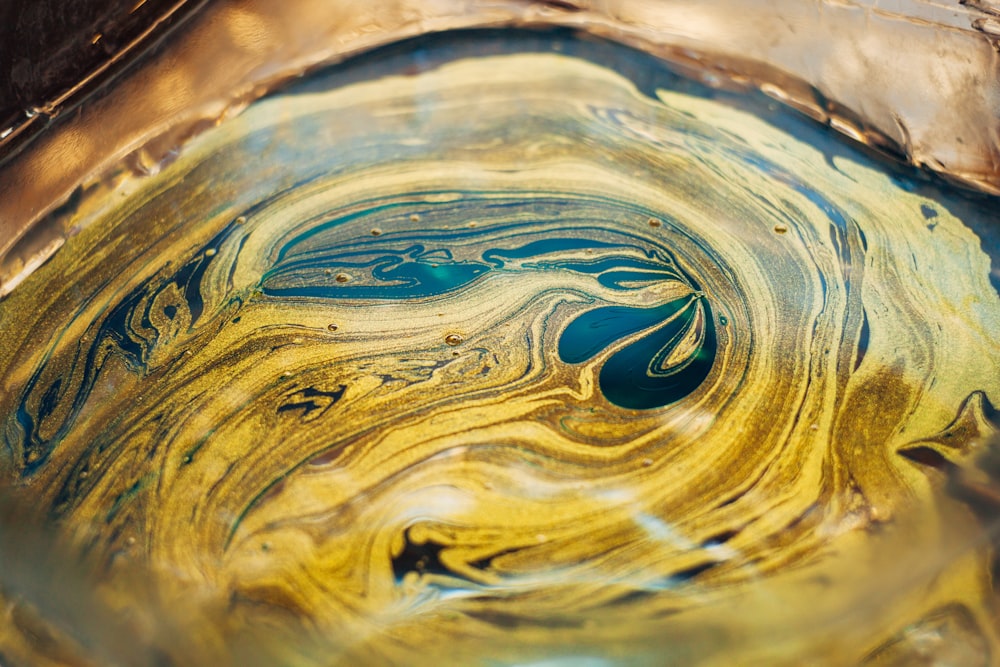 a close up of a glass bowl with yellow and blue swirls