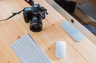 A professional photo of a camera and a notepad on a desk.