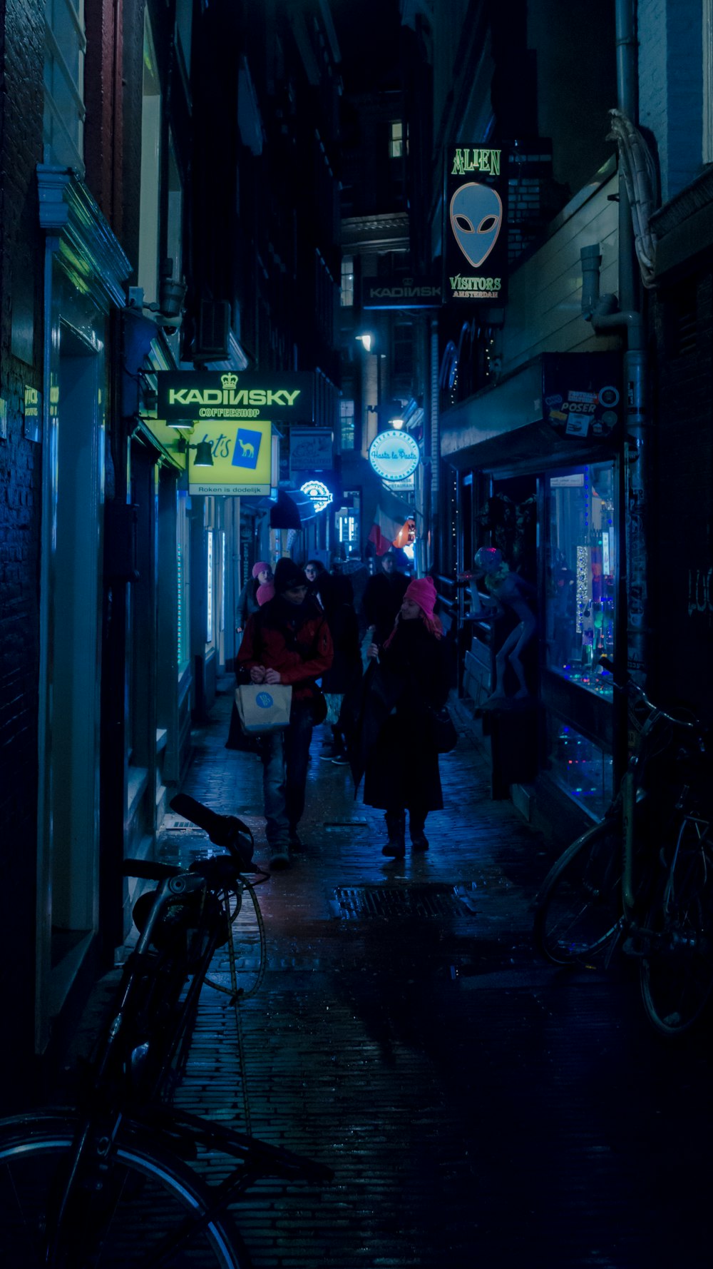 people walking on road between buildings