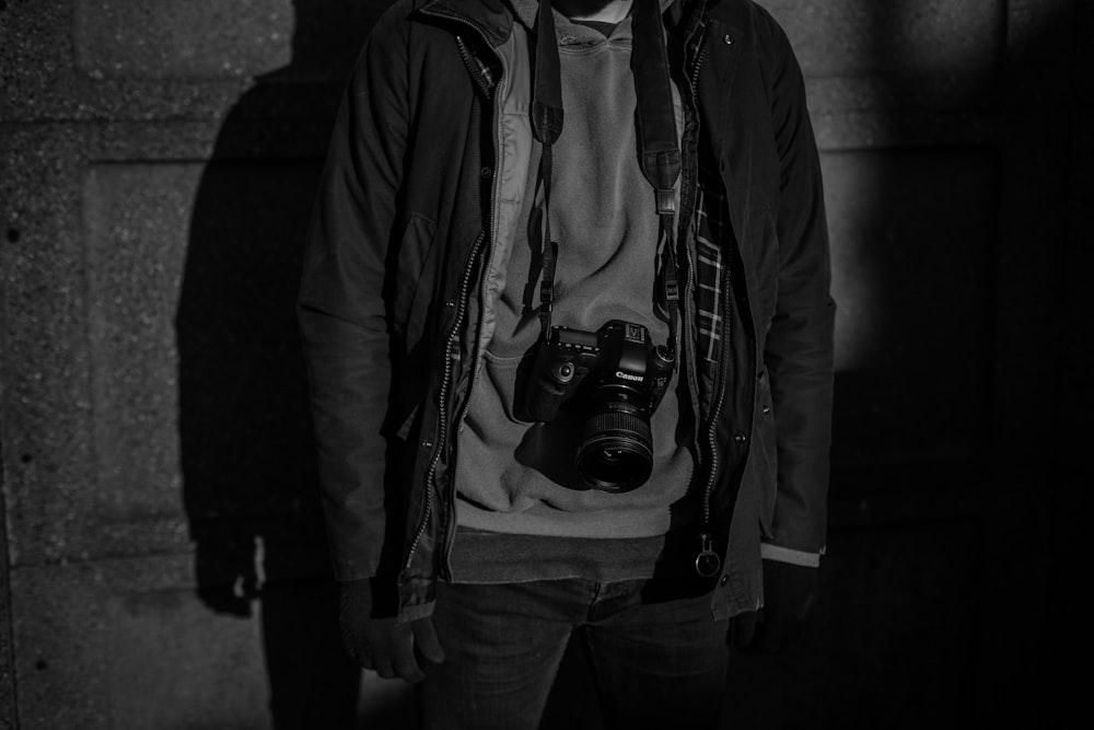 grayscale photography of person standing behind wall