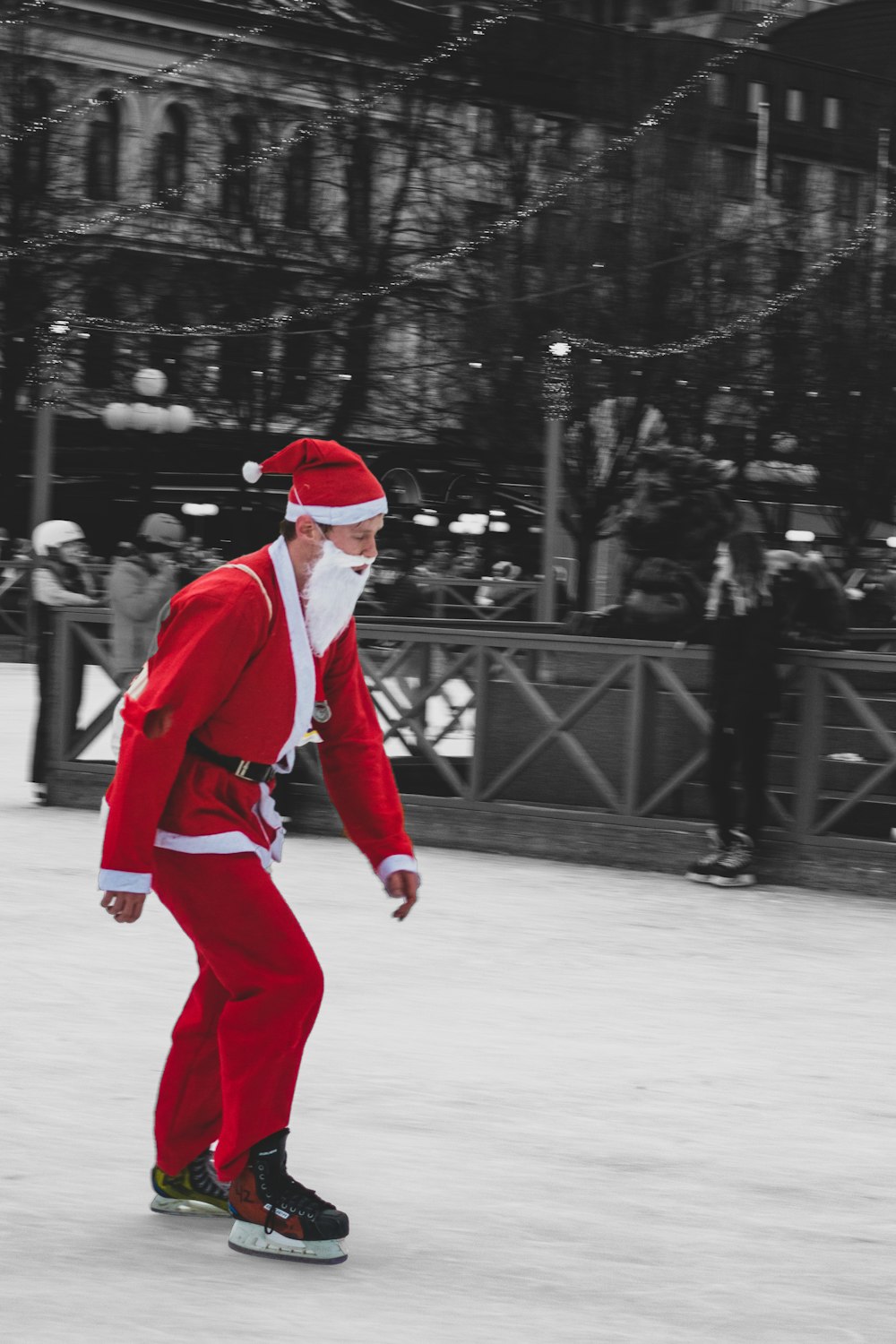 Mann trägt Weihnachtsmann-Anzug, während er Schneehautstiefel benutzt