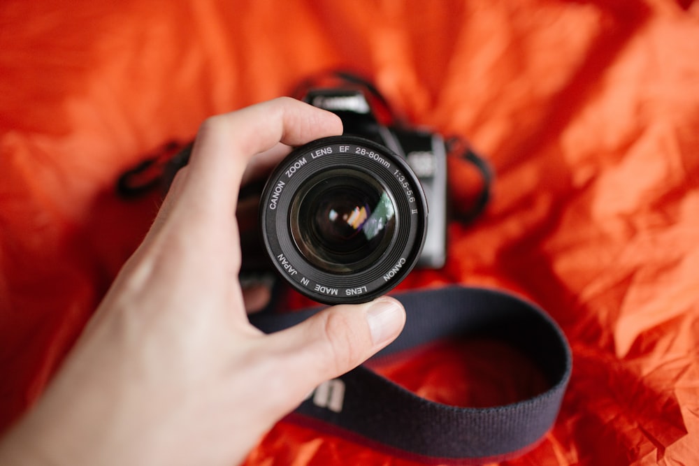 black DSLR camera on orange textile