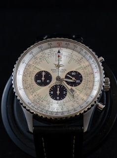 round silver-colored analog watch with black leather band