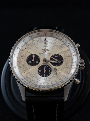 round silver-colored analog watch with black leather band