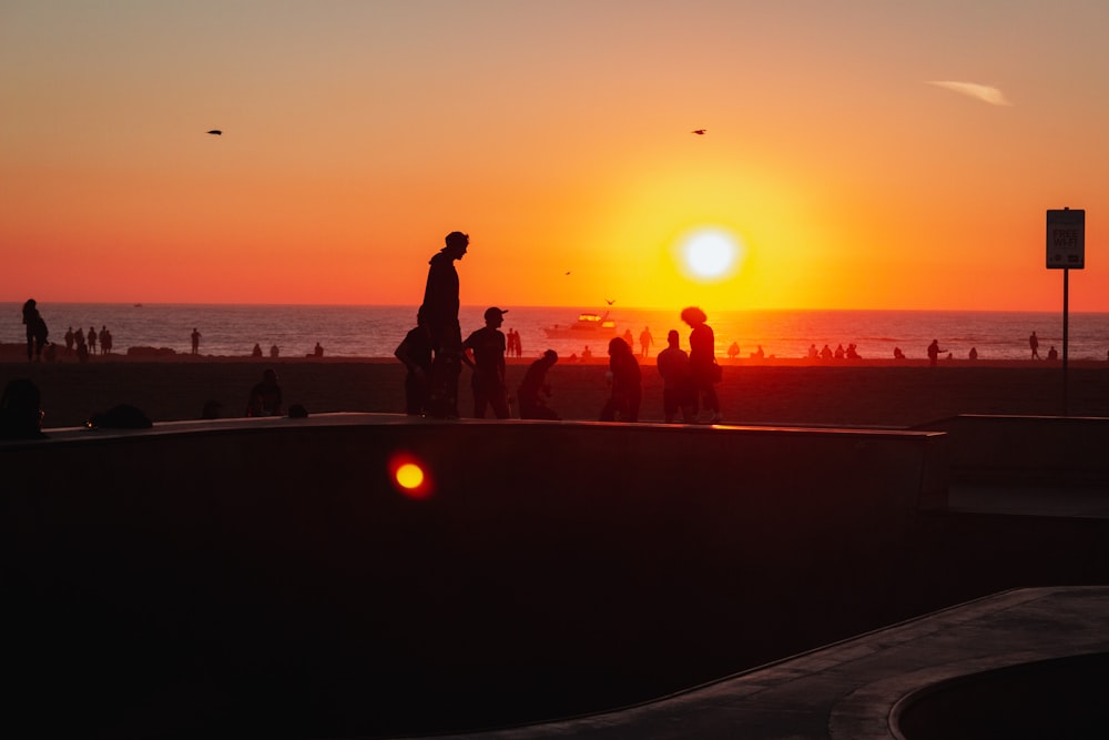 silhouette of people on the the beach during sunset