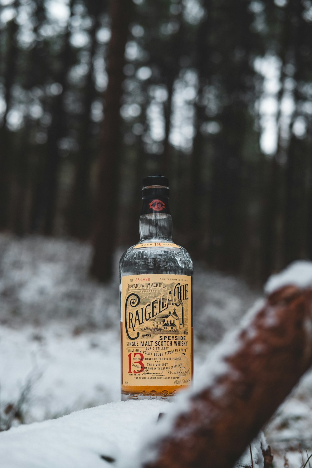 Craigelagie scotch whisky bottle on snow at the woods
