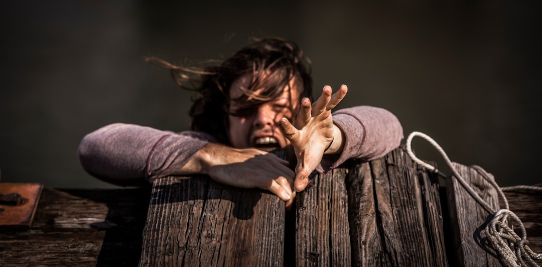 woman holding on brown wooden plank