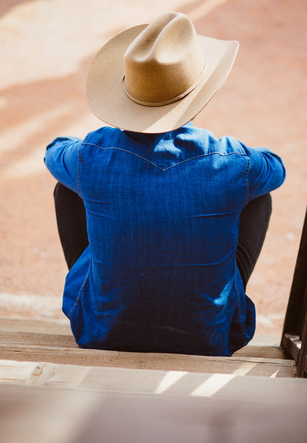 파란색 드레스 셔츠와 베이지색 카우보이 모자를 쓴 남자
