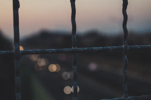 Close-up of security fence with integrated sensors at dusk