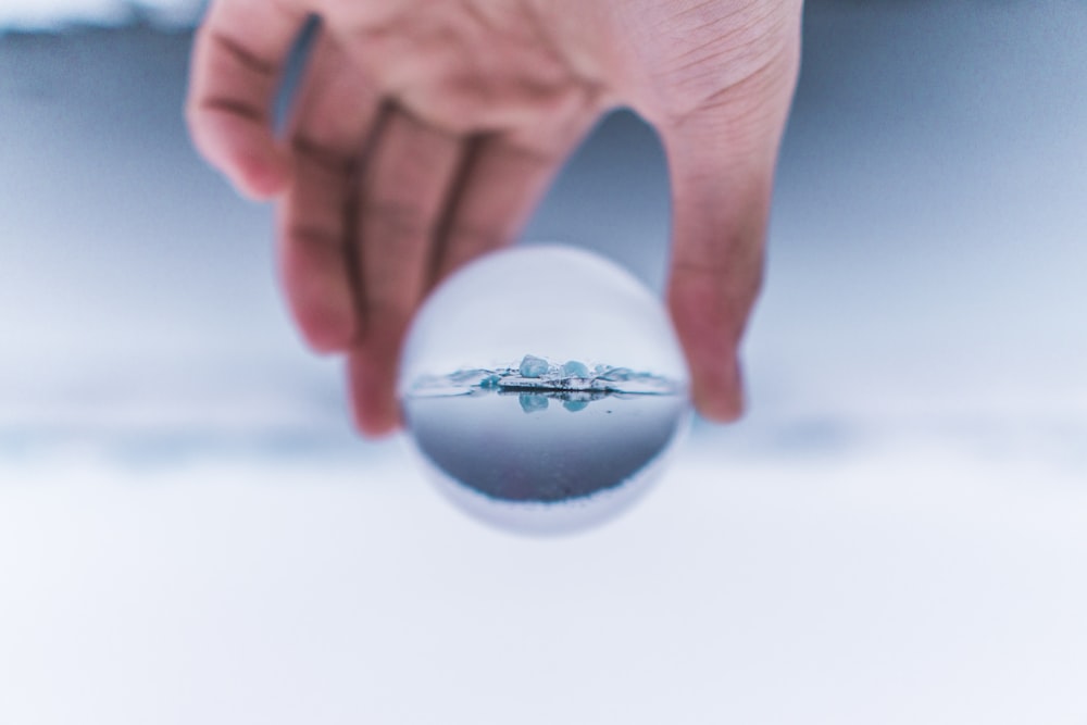 person holding glass ball