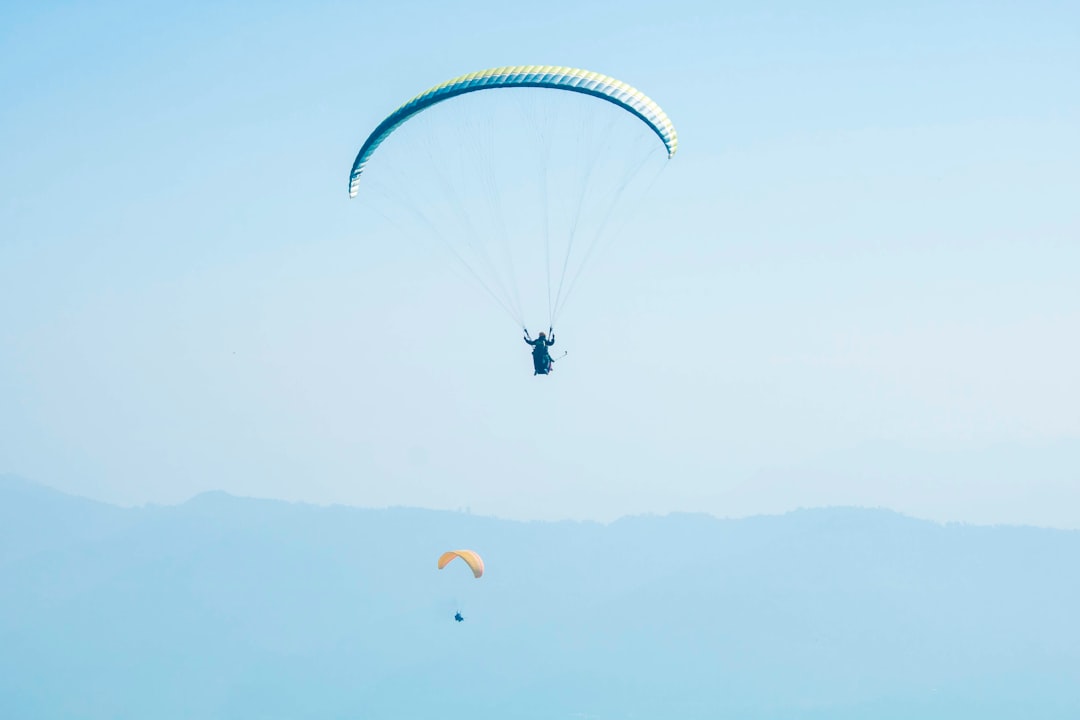 man parachuting under blue sky