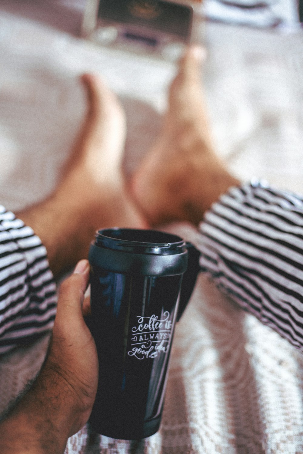 shallow focus photo of person holding plastic cup