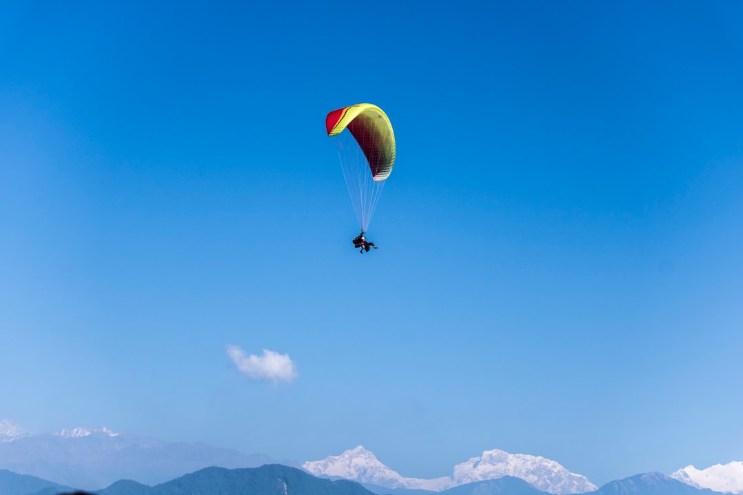 person paragliding under blue sky