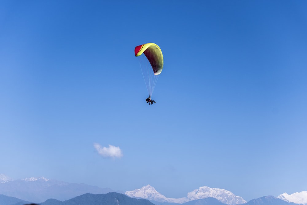 person paragliding under blue sky