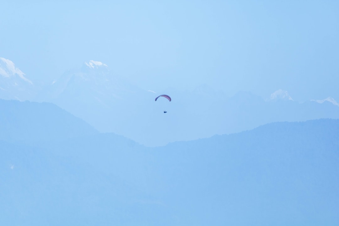 a couple of kites that are flying in the sky, Paragliding around the Himalaya