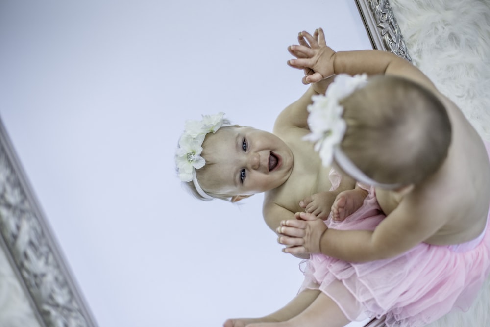 toddler facing mirror while smiling