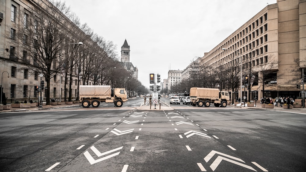 two trucks on road near brow buildings