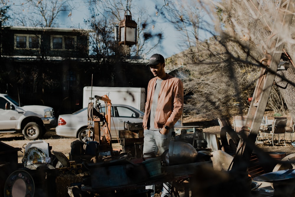 man standing near vehicle parts during daytime