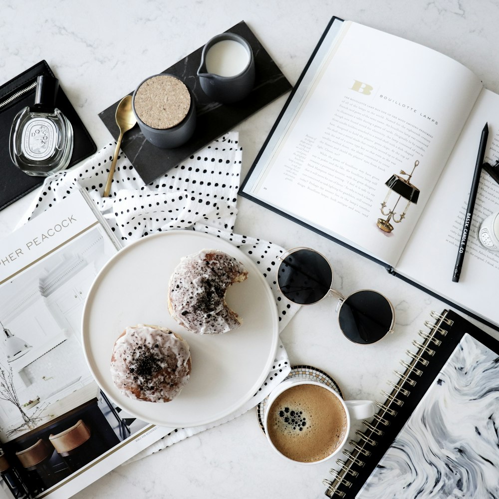 white ceramic mugs near books and sunglasses