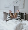 woman sitting on bed while holding book