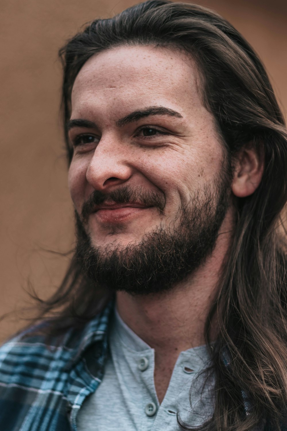 smiling man in blue and black plaid shirt