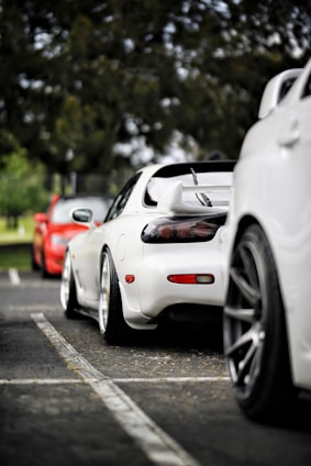 three white and red vehicles under trees