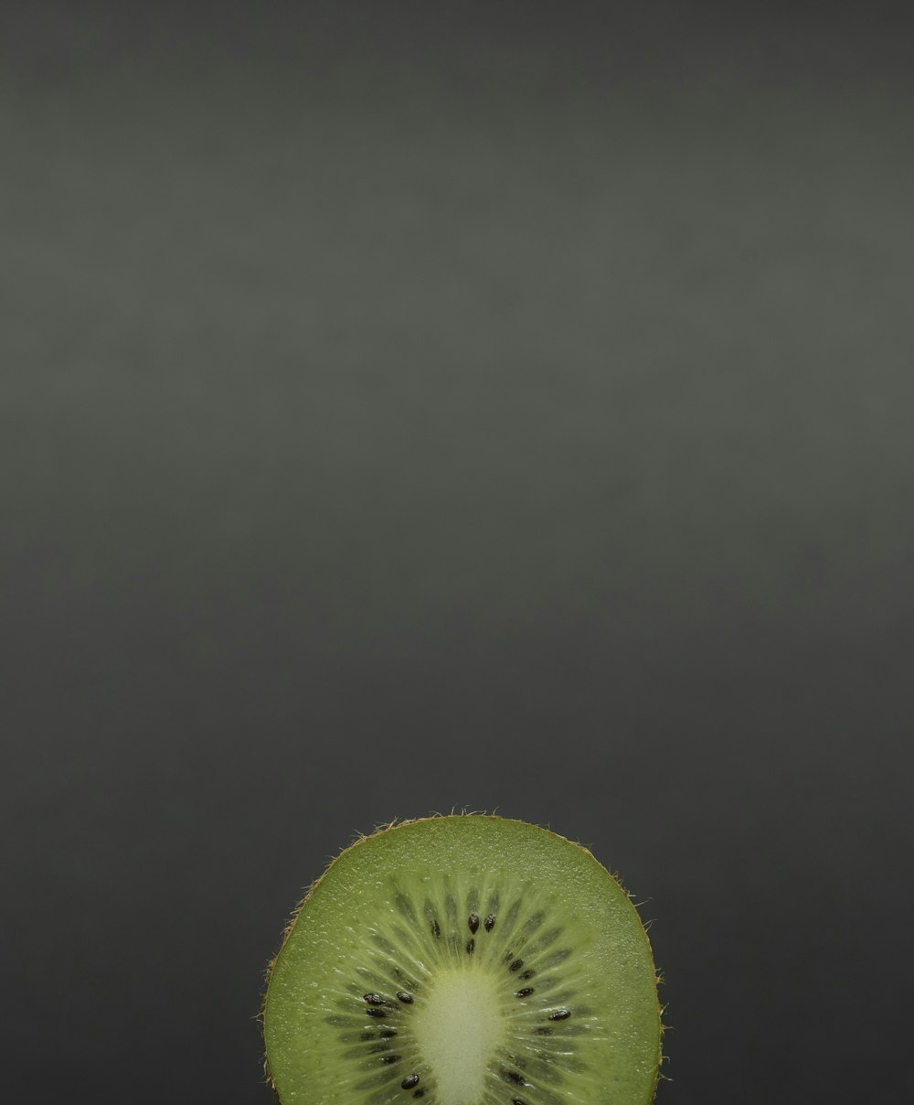 green sliced kiwi fruit on grey panel