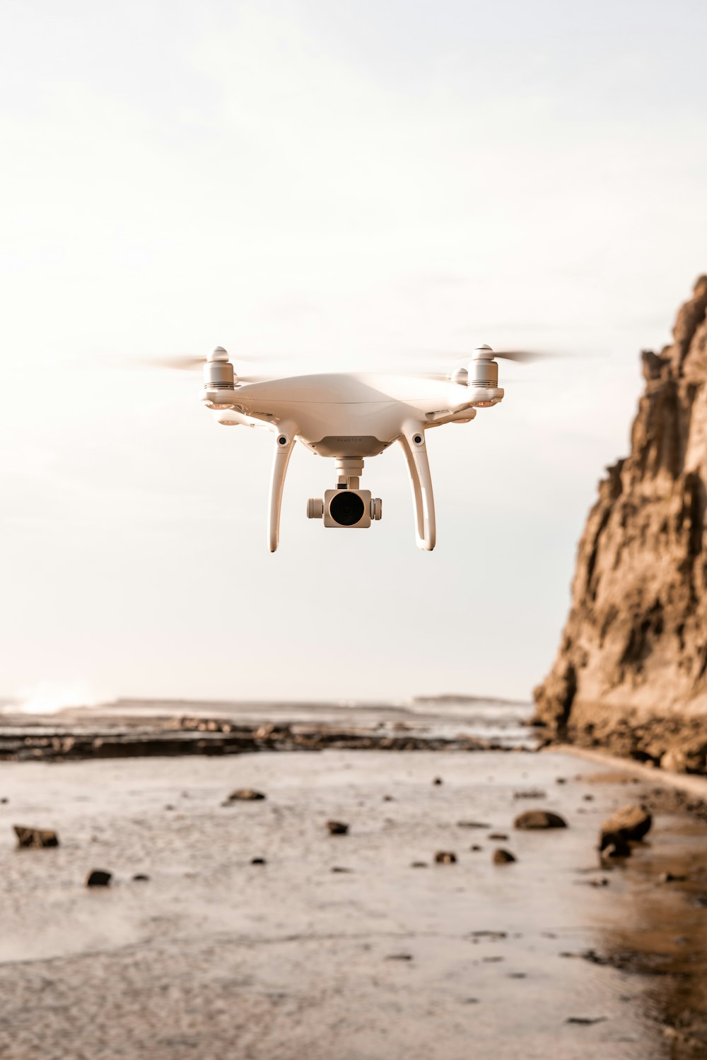 white quadcopter drone near mountain during daytime