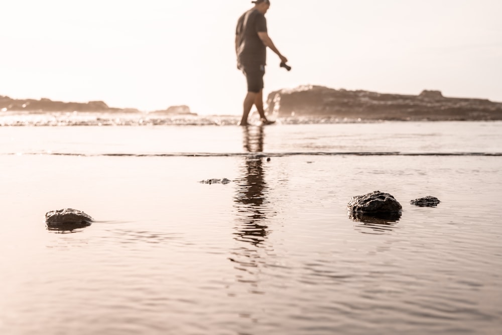 man walking beside body of water