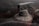 A dusty fire extinguisher shrouded in intricate cobwebs, suggesting long-term neglect. The ambient lighting is dim, creating a sense of abandonment and mystery.