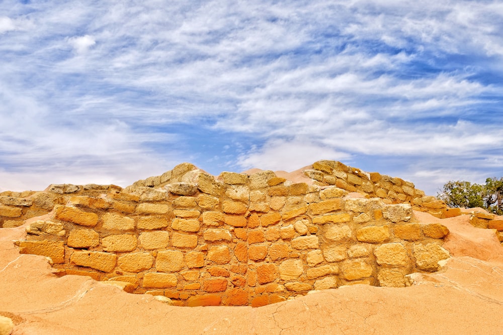 brown brick wall on open brown field during daytime